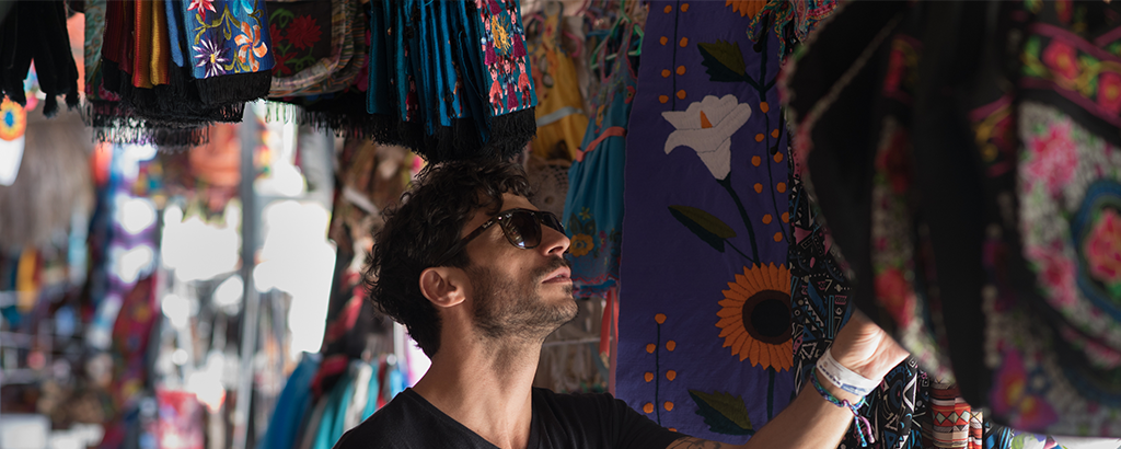 hombre joven viendo artesanias telas artesanales en cancun